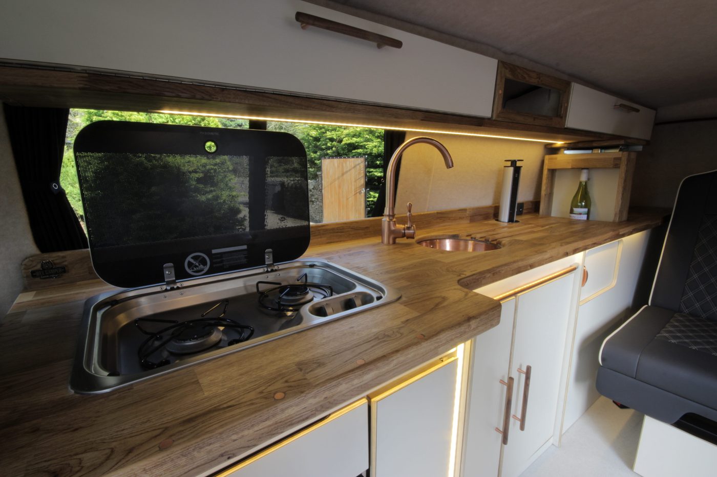 A custom-built campervan interior with new wood cabinetry and storage
