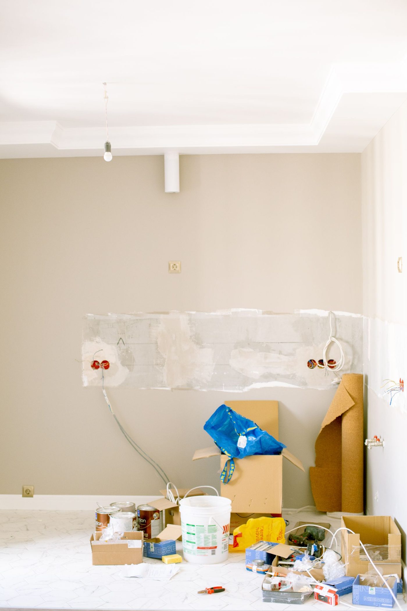 Tools, paint cans, and renovation materials scattered across a floor during an interior remodel project