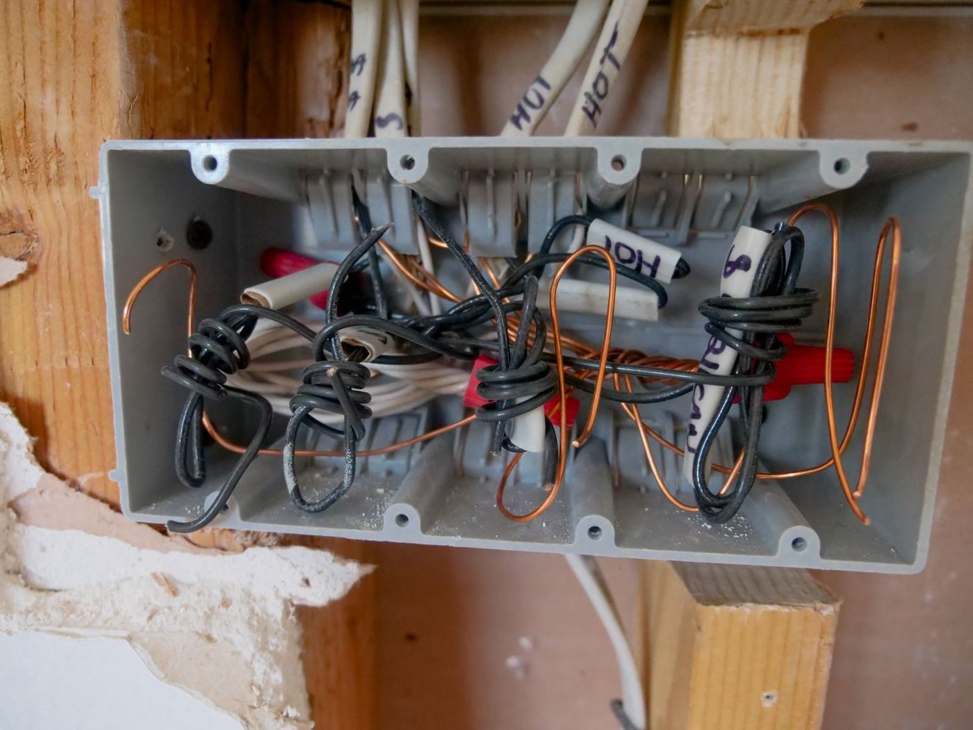 A close-up view of an opened electrical switchboard with tangled wires and cables
