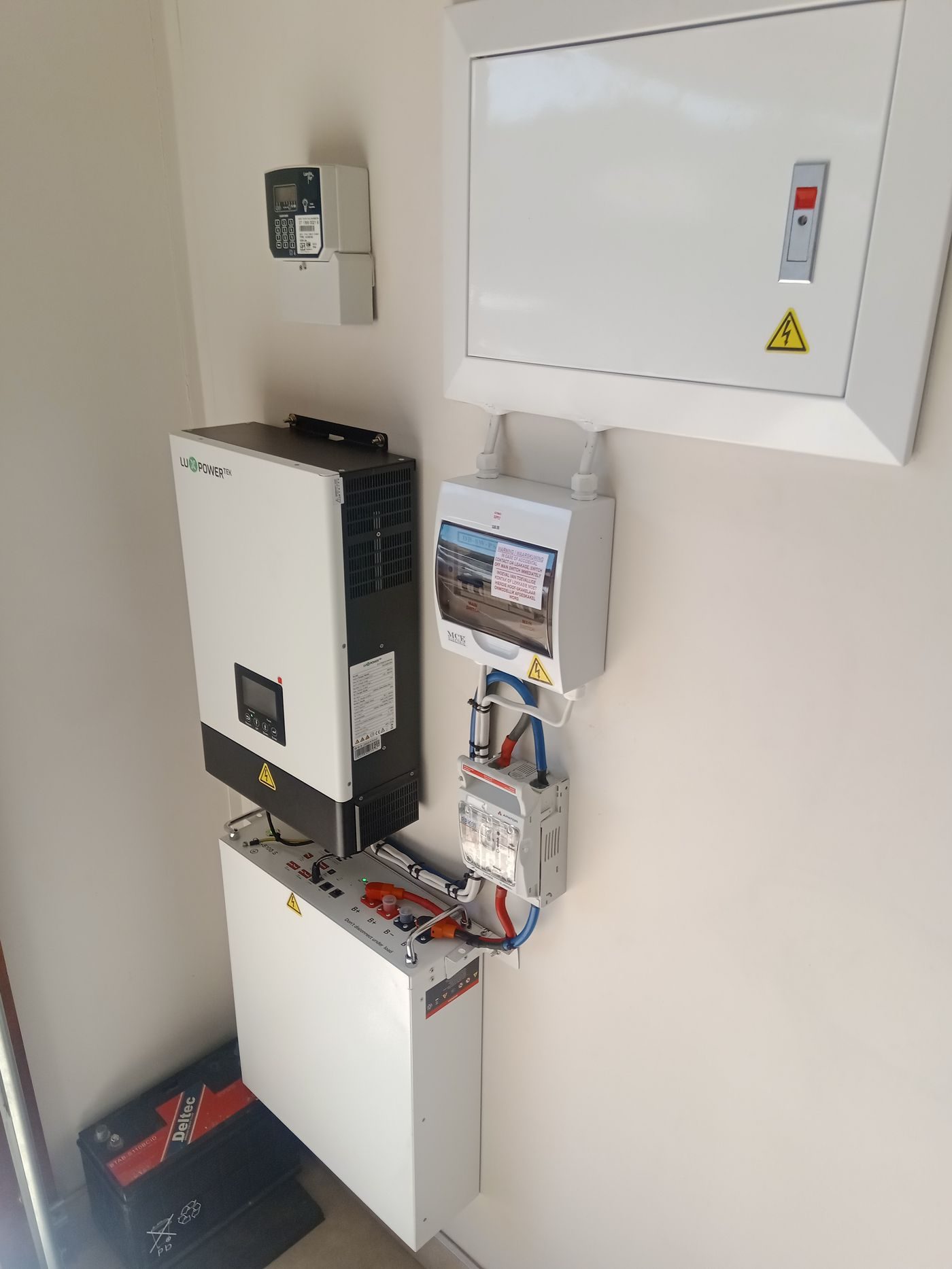 A lithium battery unit wall-mounted next to a hybrid power inverter