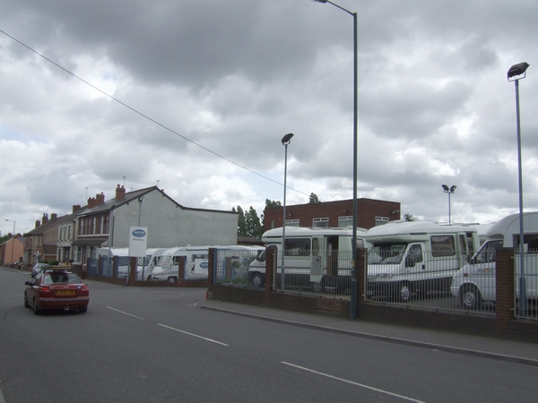 Row of motorhomes parked for sale at a dealership lot