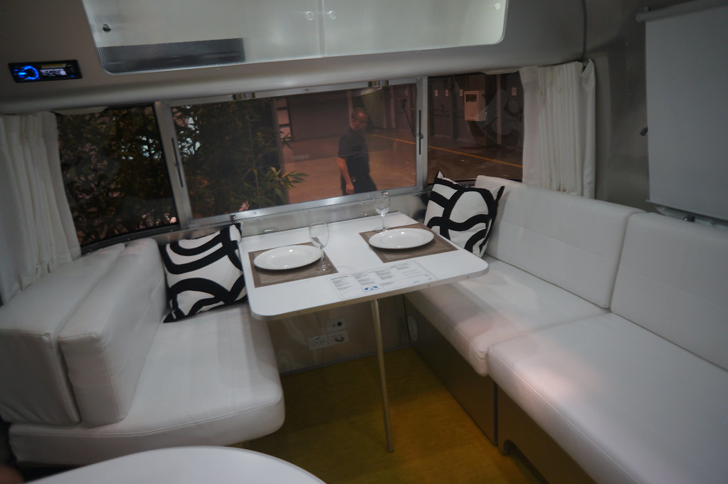 A modern Airstream trailer dinette booth with white leather seating after an interior remodel
