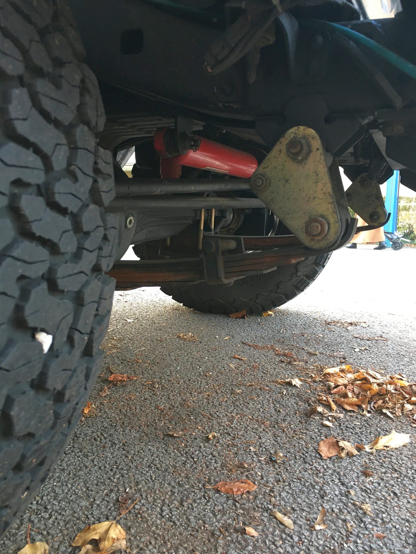 Close-up of a vehicle's leaf-spring front suspension and steering linkage