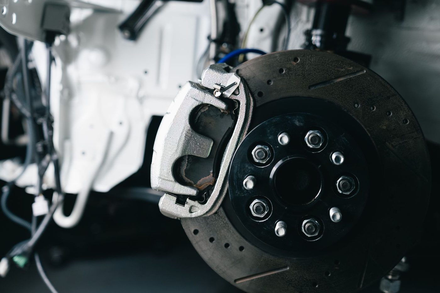 Close-up of a disc brake caliper and rotor mounted on a vehicle's suspension