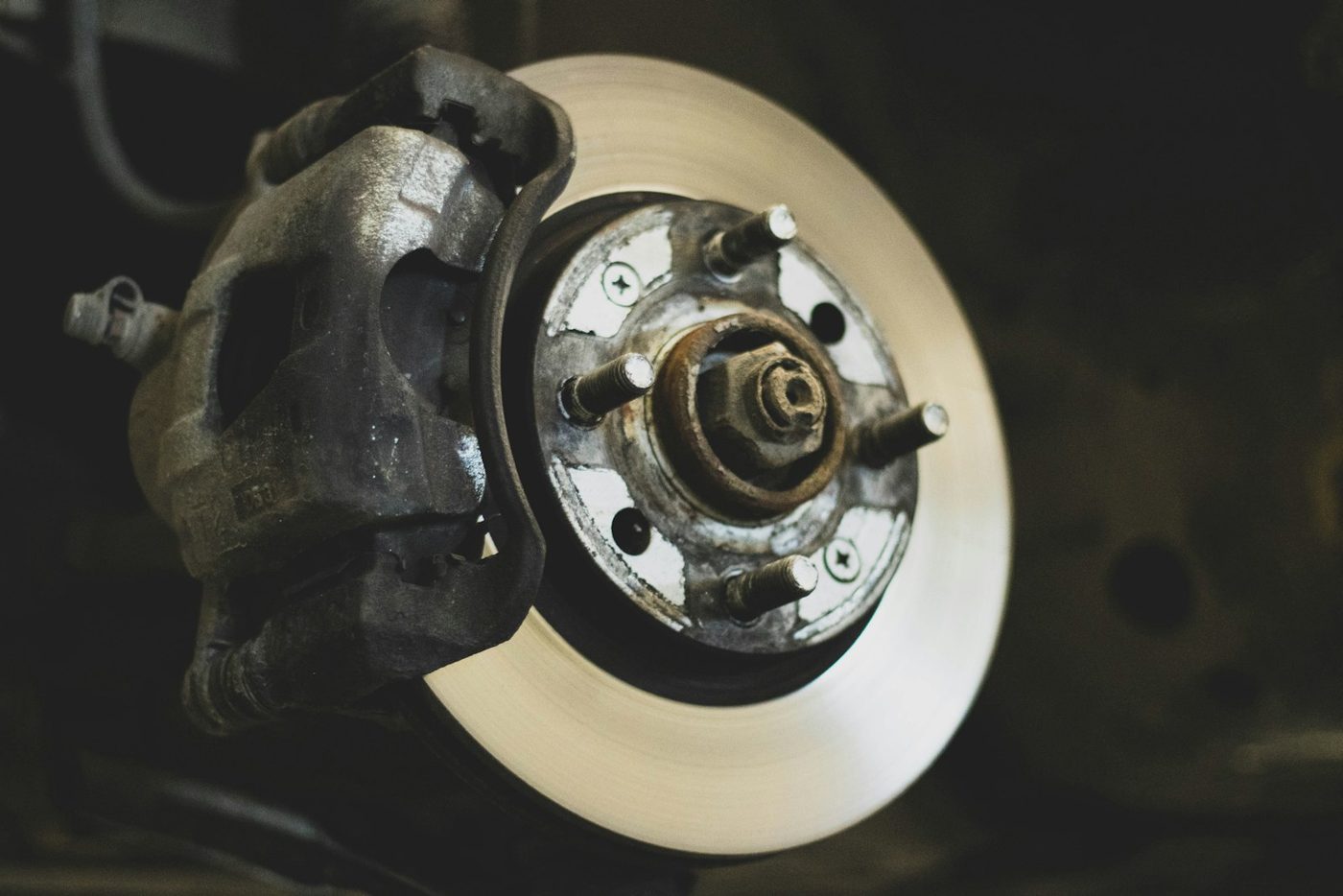 Close-up of a vehicle's disc brake caliper and rotor with visible wheel hub