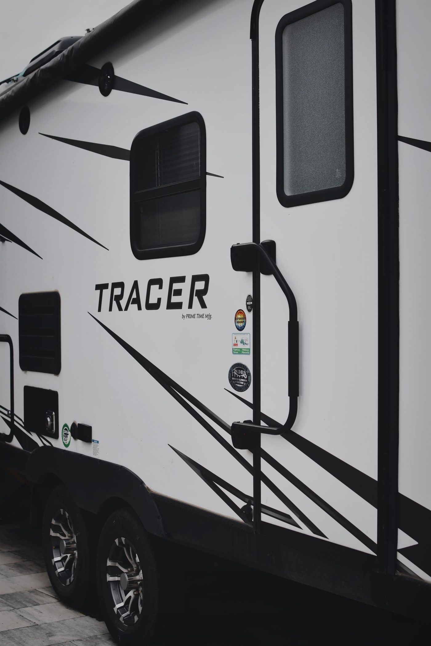 Close-up of a travel trailer's door, decals, and wheel well