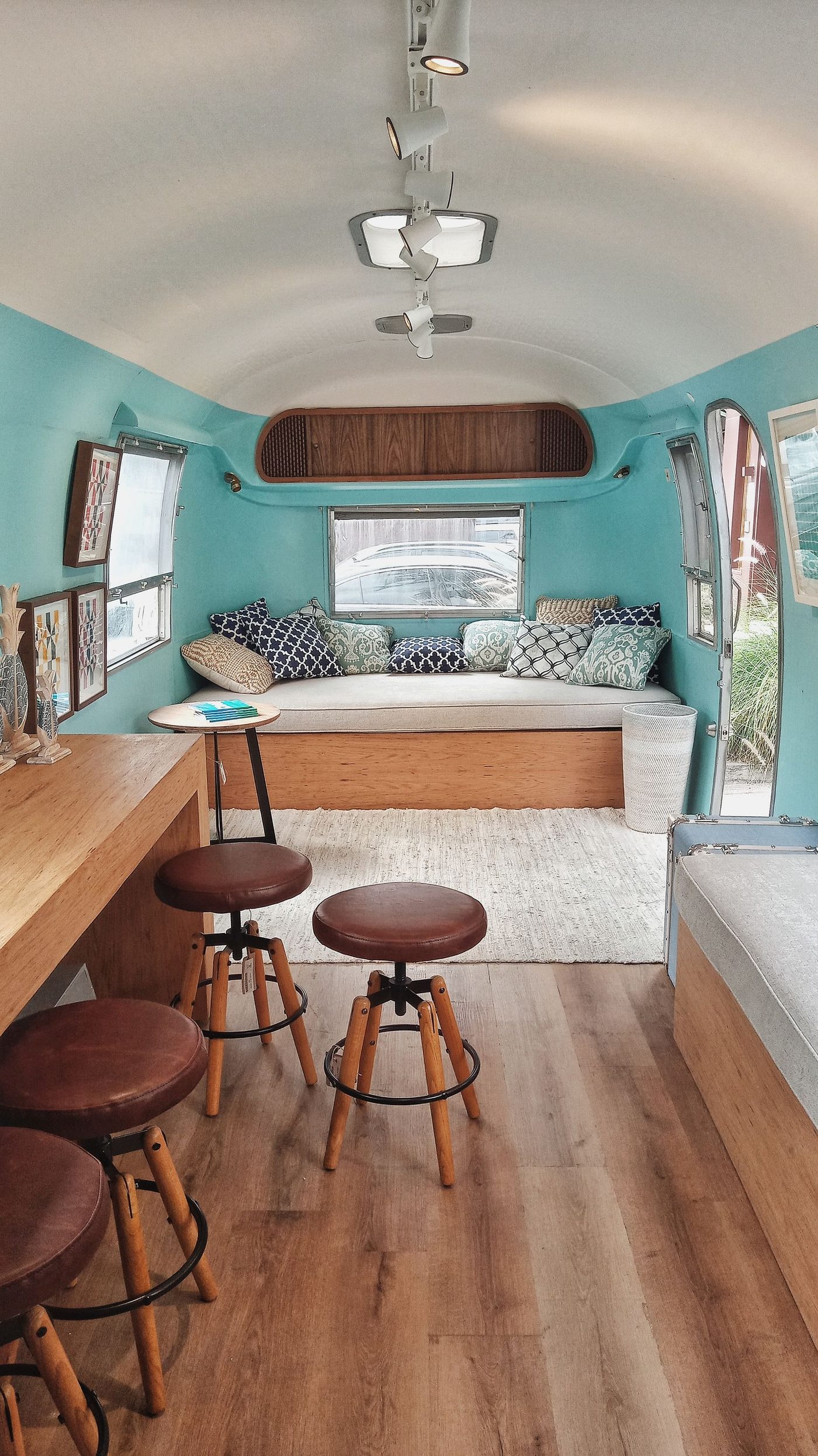 A renovated camper van interior with new hardwood-style flooring and built-in seating