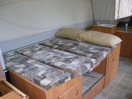 RV dinette converted into a sleeping bed with patchwork cushions