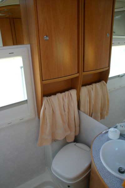 A toilet installed in the bathroom compartment of a motorhome