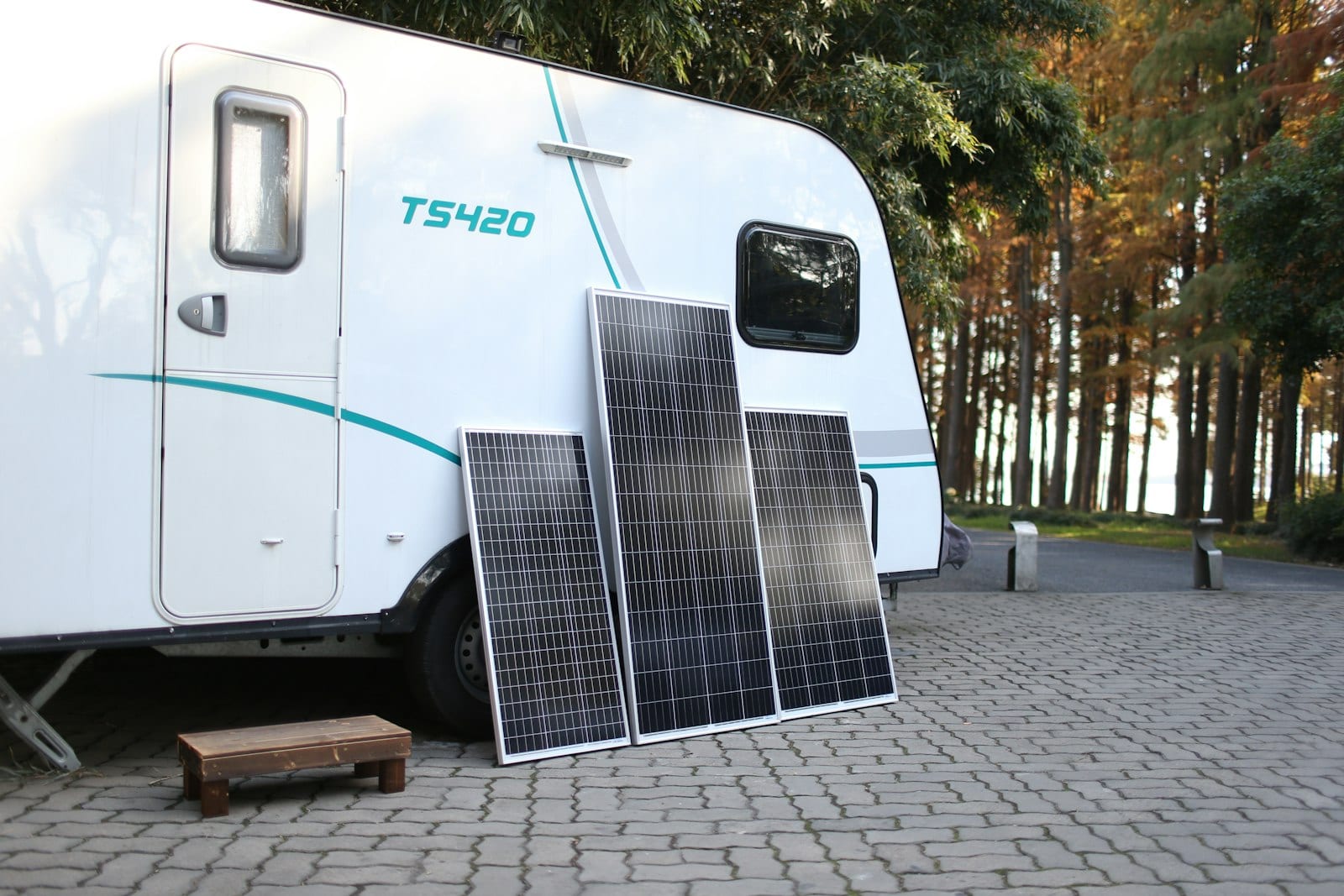 A white travel trailer with a solar panel mounted on its roof